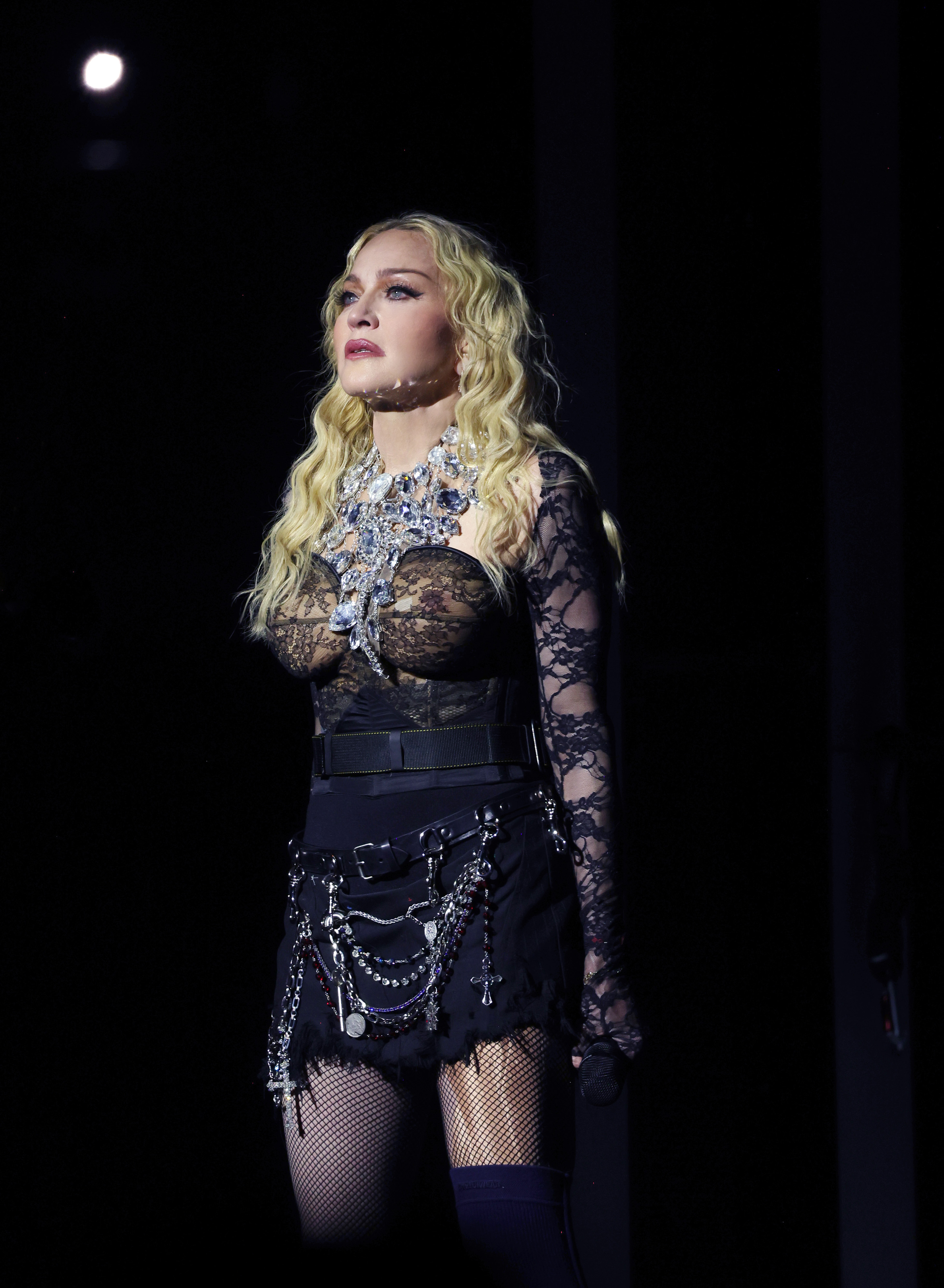 Madonna wearing all black and performing on stage in London