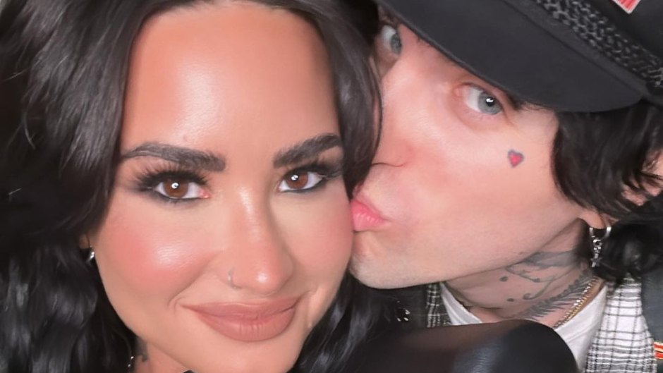 Demi Lovato smiles as her boyfriend Jutes kisses her on the cheek