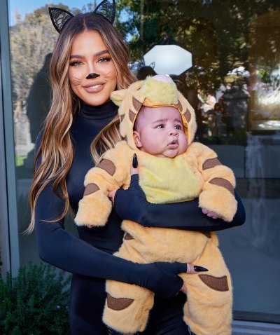 Khloe Kardashian dressed up in a cat costume holding her son, Tatum, dressed up in a lion costume