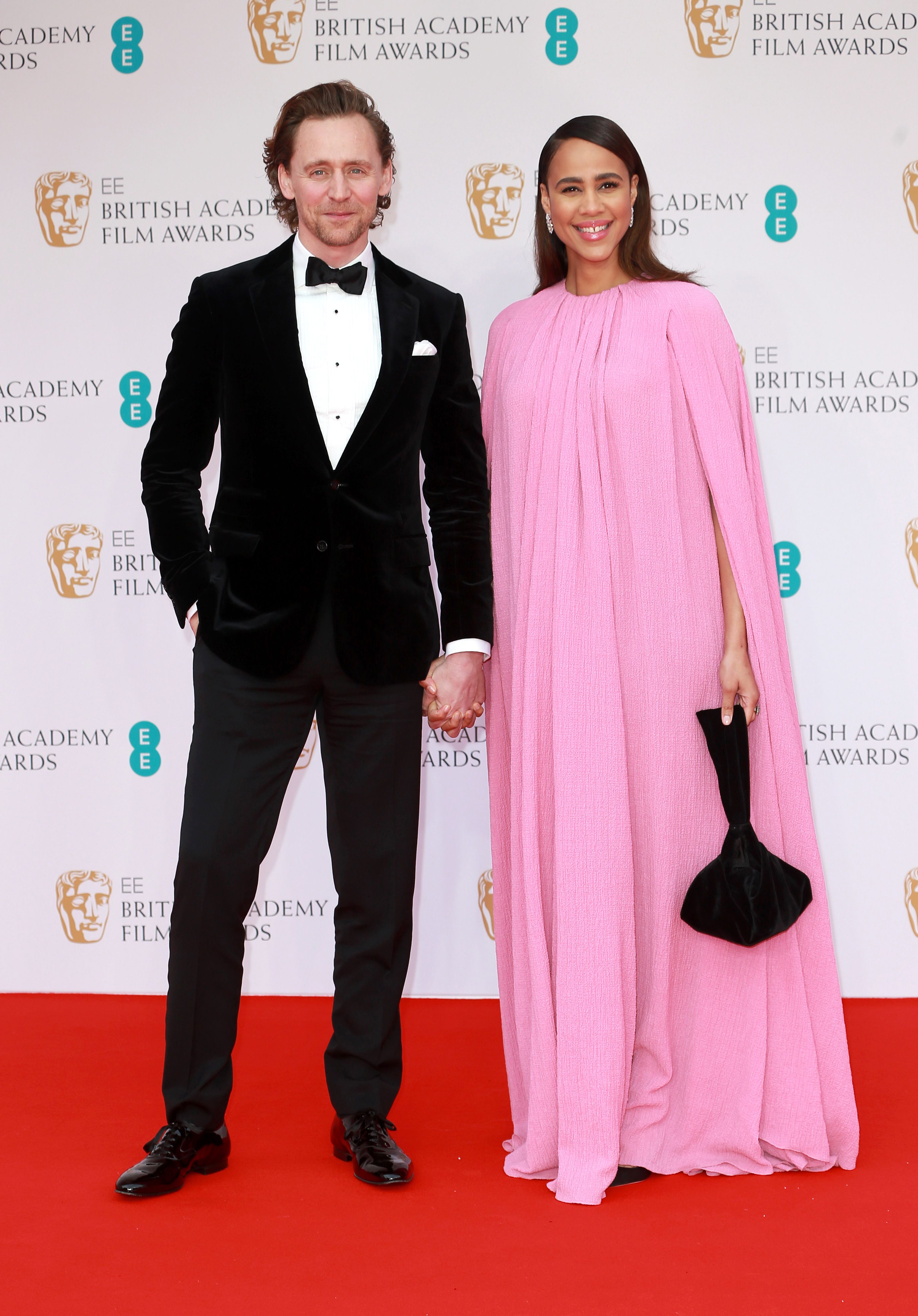 Tom Hiddleston and Zawe Ashton hold hands on a red carpet