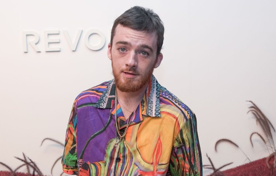 Angus Cloud wearing a multi-colored colalred T-shirt at a Revolve event