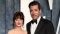 Zooey Deschanel wearing a silver winged gown next to Jonathan Scott wearing a black tuxedo
