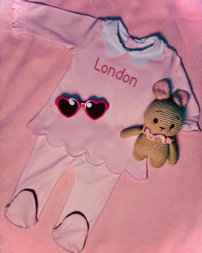 Paris Hilton announced the arrival of her second baby, a little girl, with a photo of a pink outfit with the name London embroidered on the front.