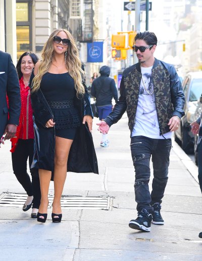 Mariah Carey and Bryan Tanaka hold hands while walking down a street in NYC.