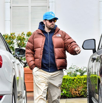 Scott Disick wears a brown puffer coat and blue hat