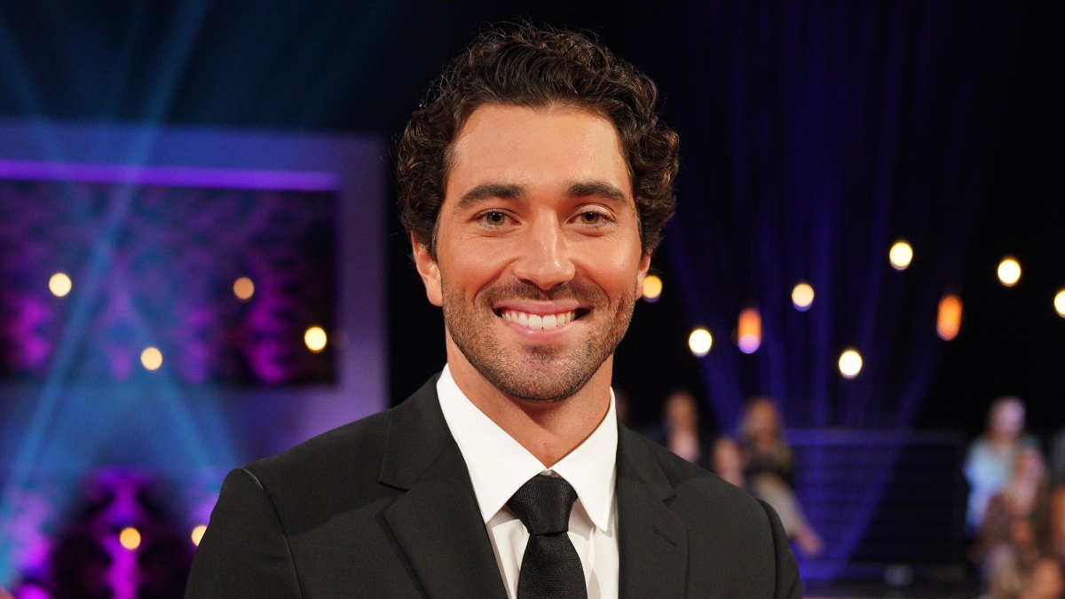 Joey Graziadei wearing a black suit and tie