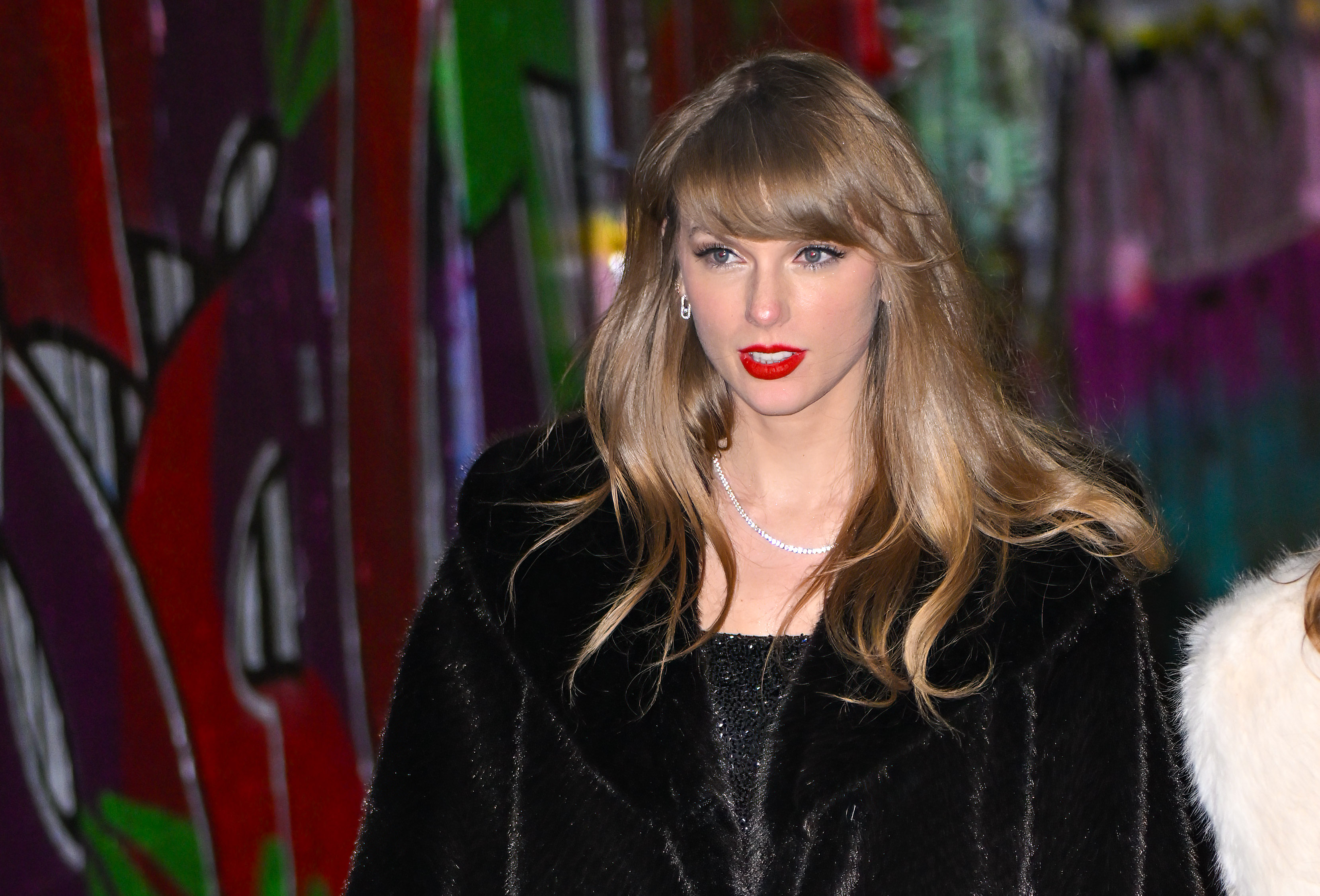 Taylor Swift in New York City wearing a black dress and coat