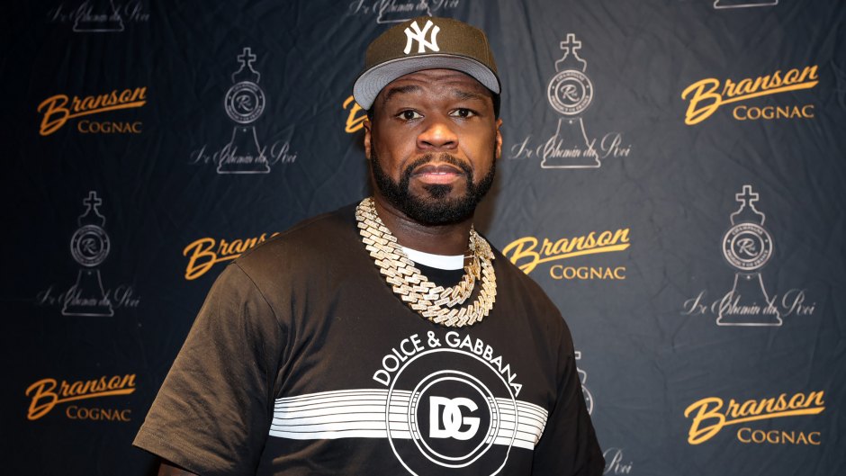 50 Cent promotes Branson cognac while wearing a black Dolce & Gabbana shirt and black New York Yankees hat