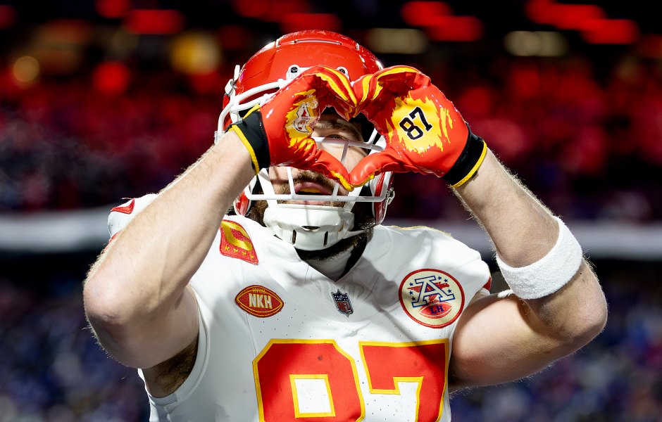 Travis Kelce giving Taylor Swift's signature heart hands gesture during Bills game.