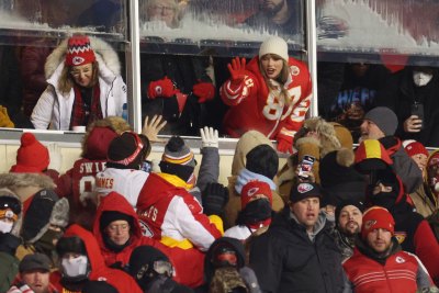 Taylor Swift waves to fans from the suite during a Chiefs game.