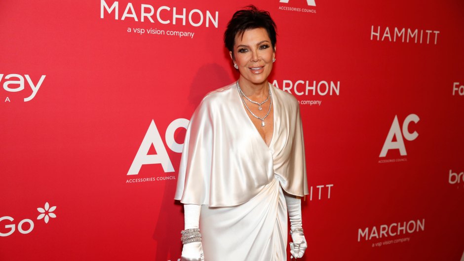 Kris Jenner poses in a white satin dress with white gloves.