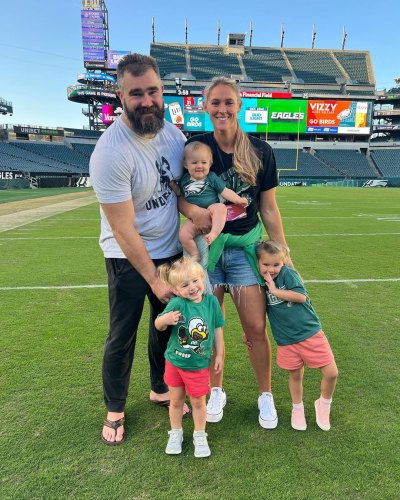 Kylie Kelce and Jason Kelce on the field with their three daughters.