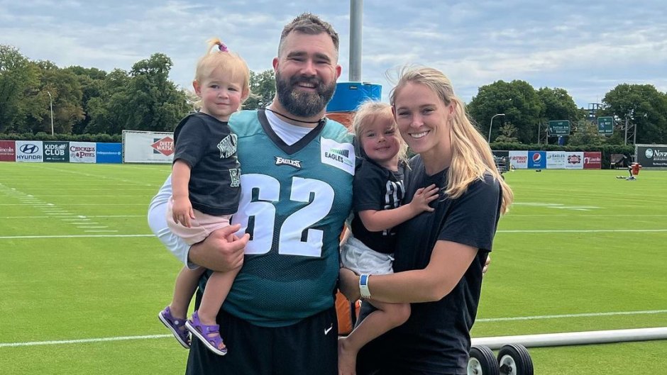 Kylie Kelce and Jason Kelce pose on the field with two of their daughters.
