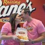 Love Is Blind's Alexa and Brennon Lemieux kiss while holding a box of Raising Cane's chicken tenders