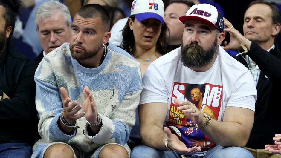 Travis Kelce and Jason Kelce sit courtside at an NBA game.