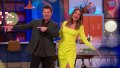 Love Is Blind's hosts Nick and Vanessa Lachey. Nick is wearing a dark suit and Vanessa has on a neon yellow dress.