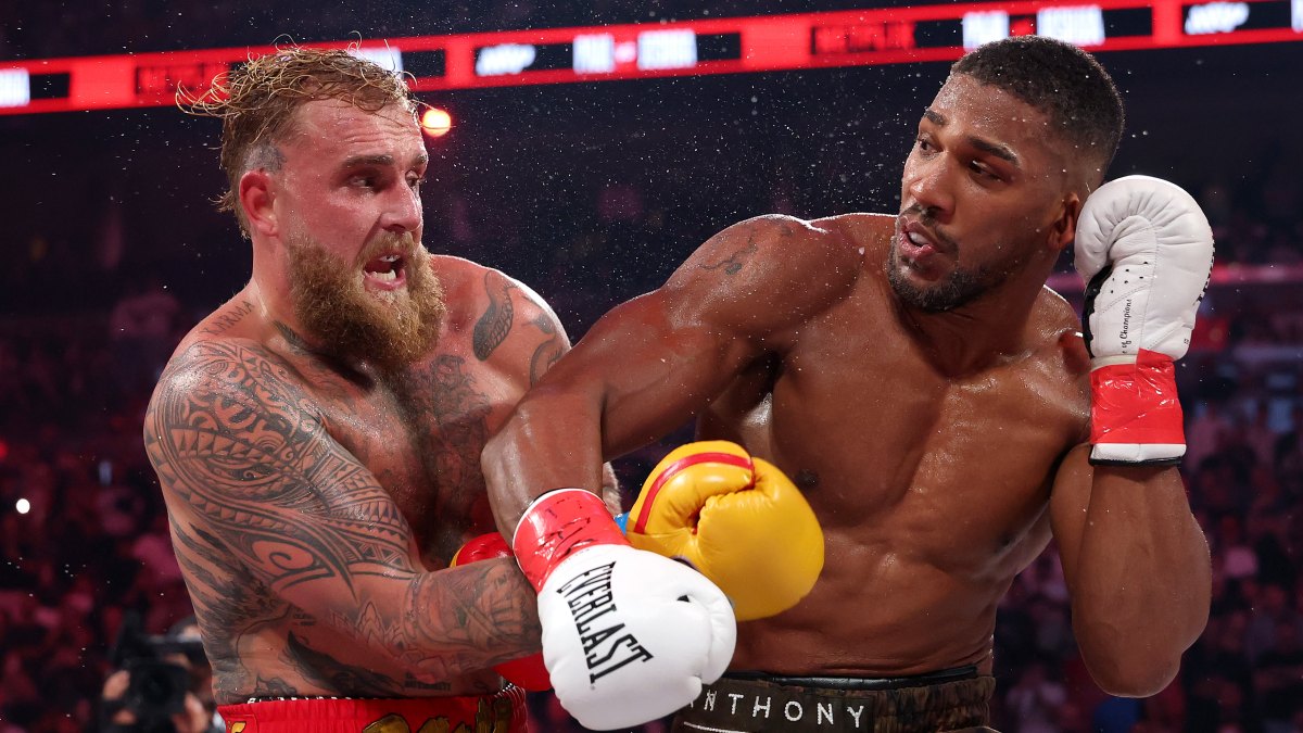MIAMI, FLORIDA - DECEMBER 19: (L-R) Jake Paul fights Anthony Joshua in their heavyweight bout during Jake Paul v Anthony Joshua at Kaseya Center on December 19, 2025 in Miami, Florida. (Photo by Ed Mulholland/Getty Images for Netflix)