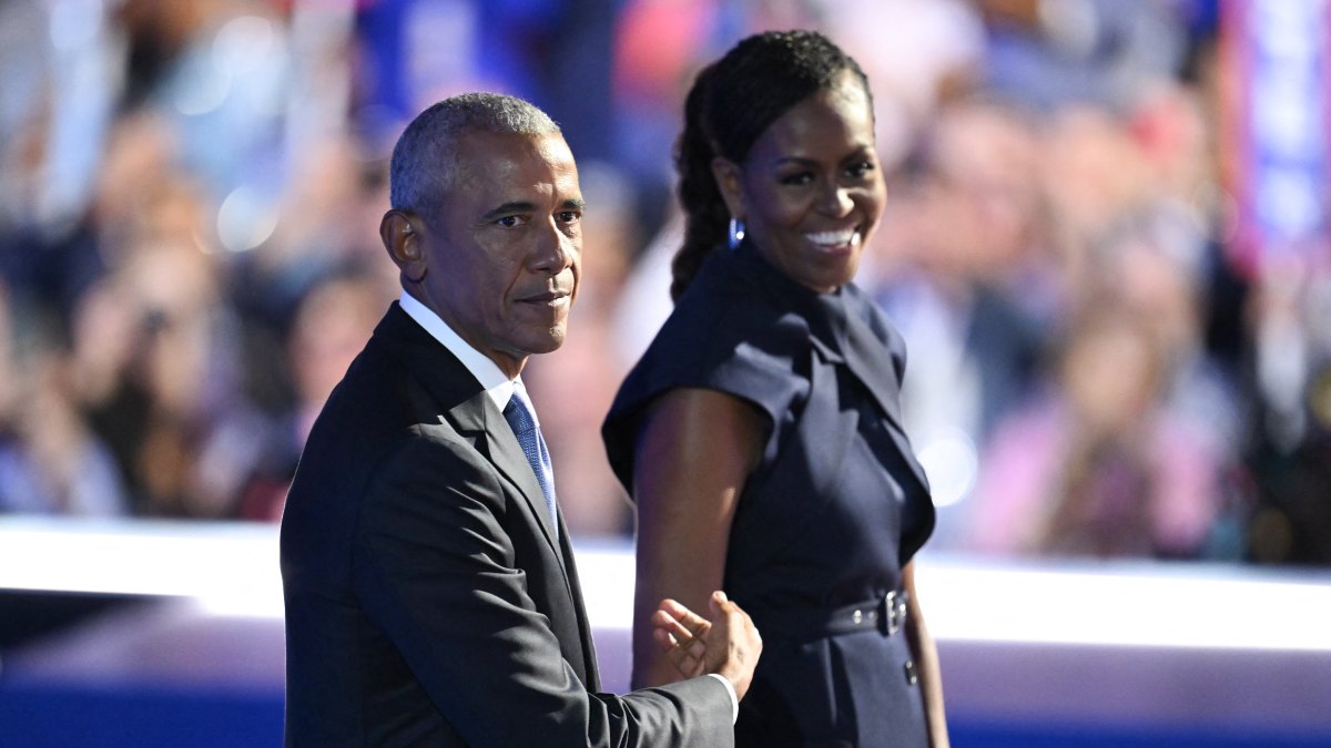 2166938545 TOPSHOT - Former US President Barack Obama and his wife and former First Lady Michelle Obama stand on stage after she introduced him on the second day of the Democratic National Convention (DNC) at the United Center in Chicago, Illinois, on August 20, 2024. Vice President Kamala Harris will formally accept the party's nomination for president at the DNC which runs from August 19-22 in Chicago. (Photo by ANDREW CABALLERO-REYNOLDS / AFP) (Photo by ANDREW CABALLERO-REYNOLDS/AFP via Getty Images)