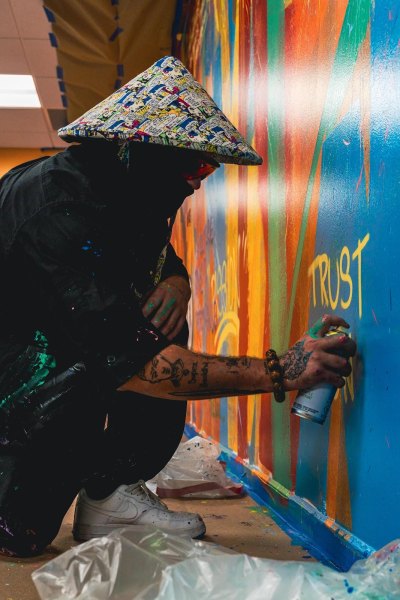 Super Buddha painting a mural