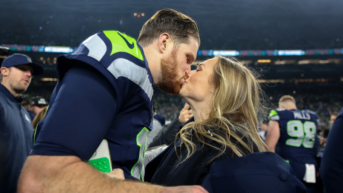 SEATTLE, WASHINGTON - JANUARY 25: Sam Darnold #14 of the Seattle Seahawks kisses his fiance Katie Hoofnagle after defeating the 31-27 in the NFC Championship game at Lumen Field on January 25, 2026 in Seattle, Washington. The Seahawks won 31-27. (Photo by Steph Chambers/Getty Images)