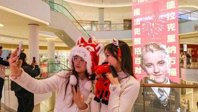 2259434667 Two women take photos in front of a giant Lunar New Year poster featuring English actor Tom Felton posing as Draco Malfoy, a character from the Harry Potter movies series, at a shopping mall in Shangqiu, in China's central Henan province on February 5, 2026. The character has become popular in China in the buildup to the Year of the Horse because the transliteration of his surname contains the Chinese characters for "horse" and "good fortune", making him an auspicious omen for the year ahead. (Photo by AFP via Getty Images) / China OUT