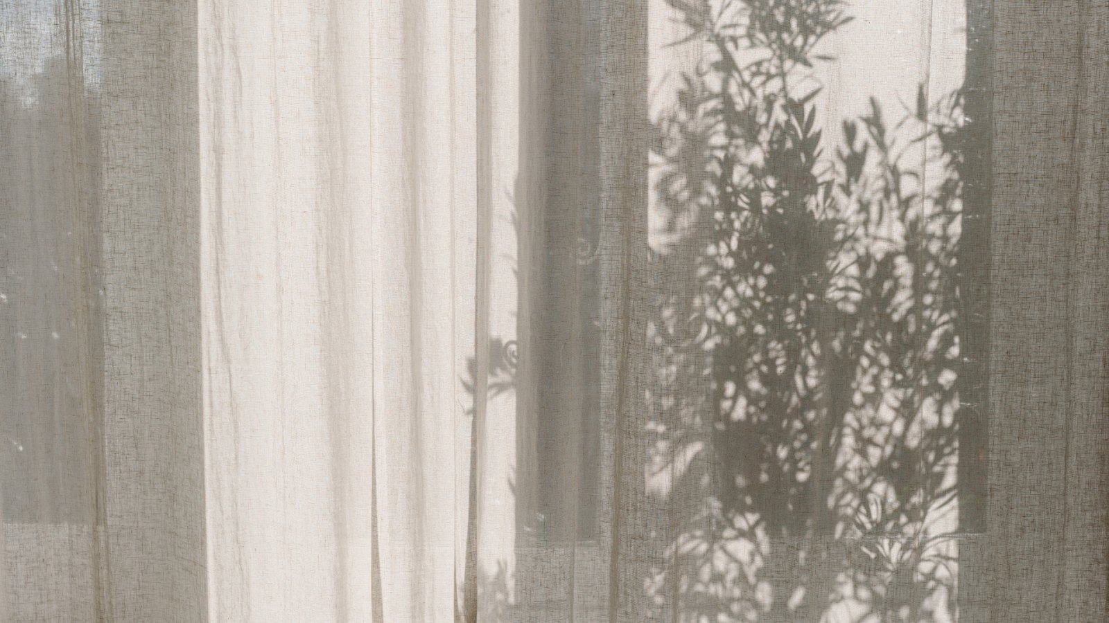 Linen curtains filtering natural sunlight in a bright modern living room