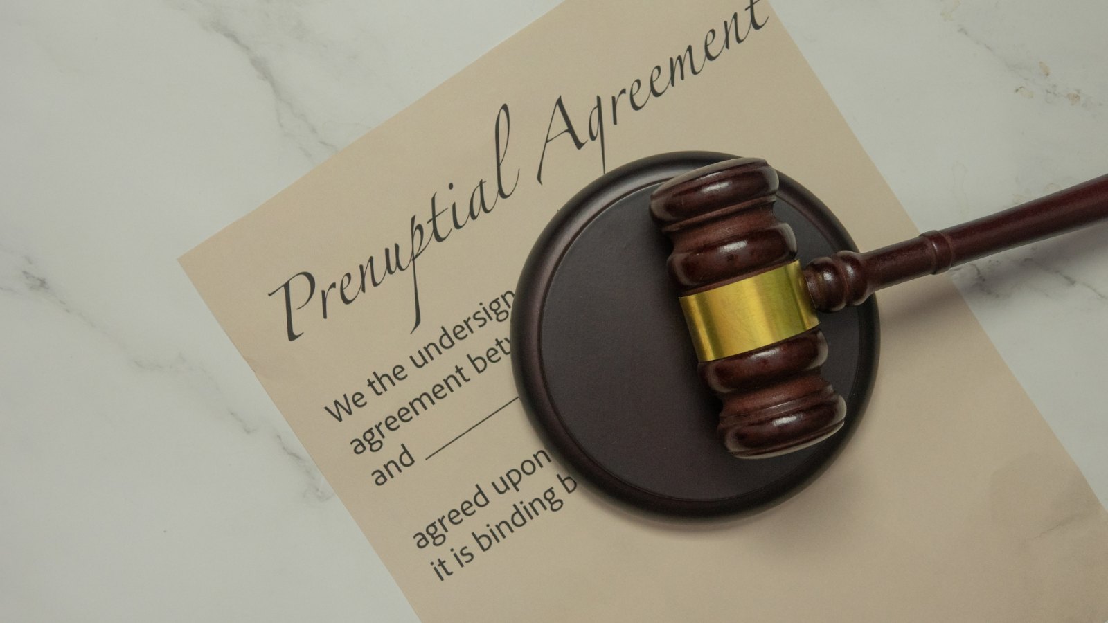 Engaged couple reviewing financial documents and a prenuptial agreement together.