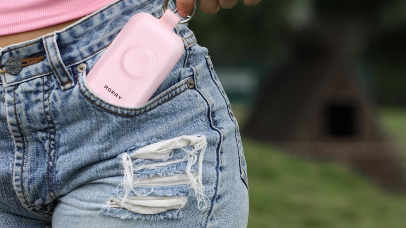 Woman holding a RORRY CharmGo portable charger in her pocket
