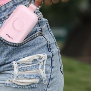 Woman holding a RORRY CharmGo portable charger in her pocket