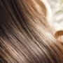 Woman using a hair straightener to style her hair