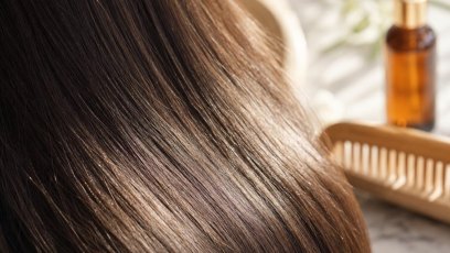 Woman using a hair straightener to style her hair